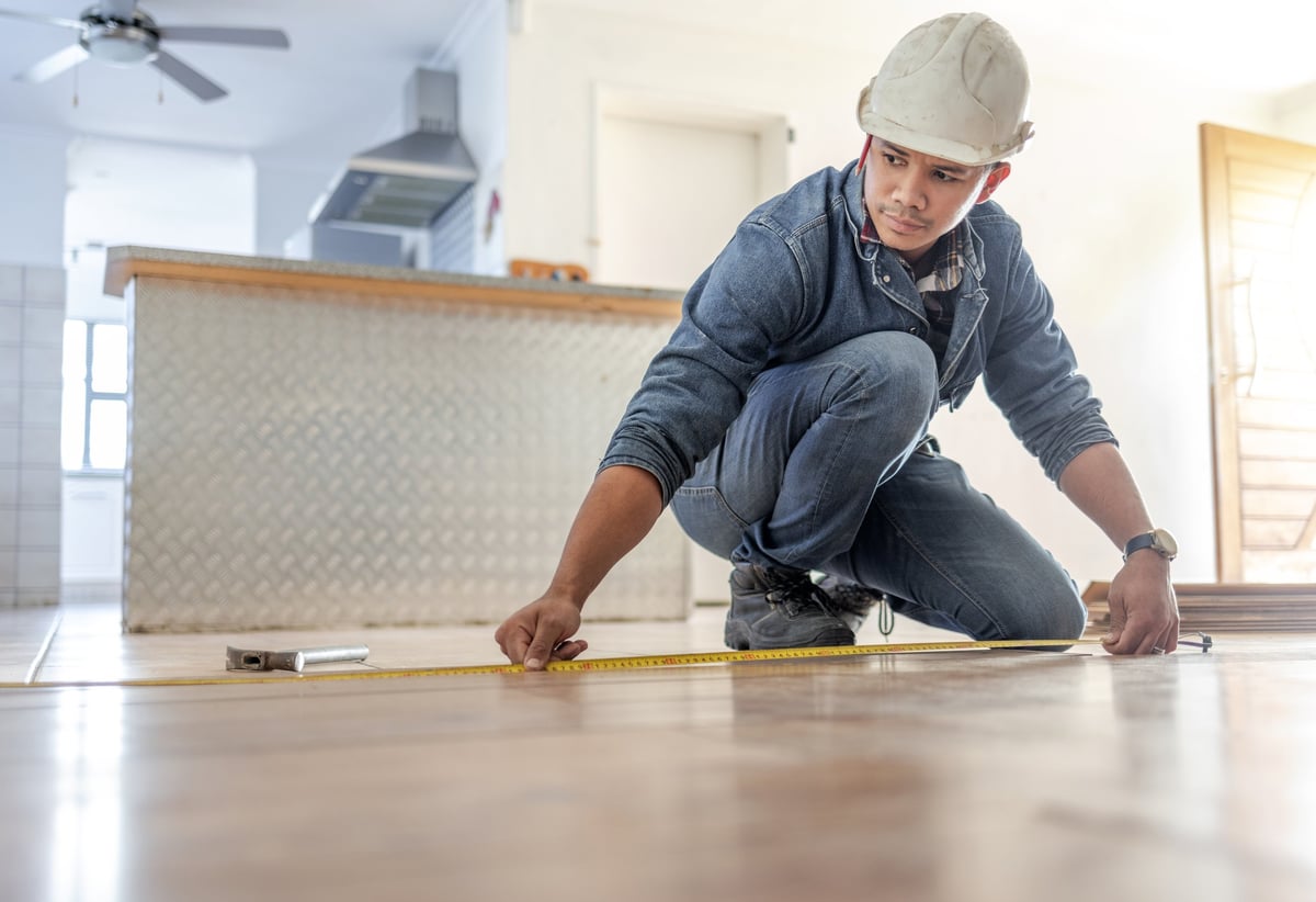 Professional contractor measuring commercial floor for assessment