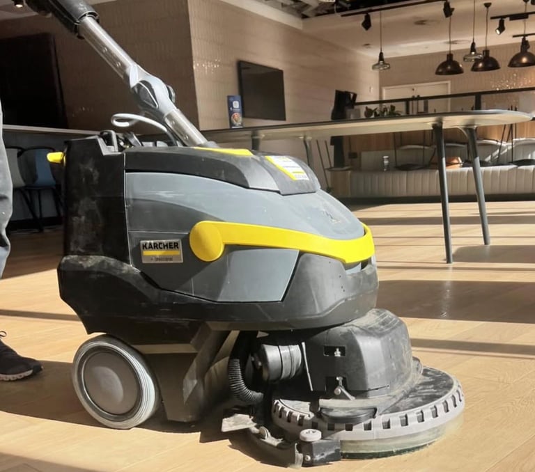 Kärcher floor scrubber machine with yellow and gray finish in commercial building interior