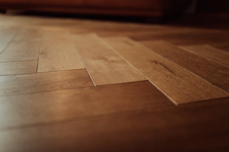 Close-up of laminate wood flooring with diagonal planks showing warm brown tones and reflective surface
