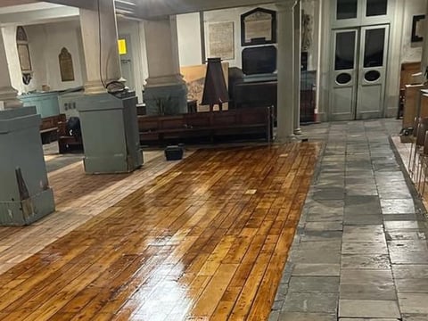 Interior of an appliance showroom with polished wood and tile flooring, displaying vintage refrigerators and stoves