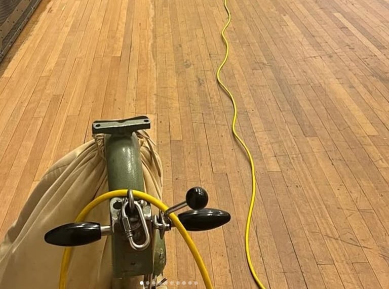 Overhead view of vintage bicycle with yellow handlebars on wooden floor, yellow cable visible
