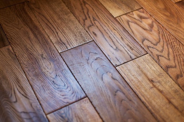 Close-up of hardwood flooring with medium to dark brown planks arranged in a staggered pattern with visible wood grain texture