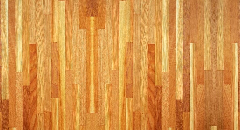 Close-up of hardwood floor with random width oak planks in varying warm honey and amber tones