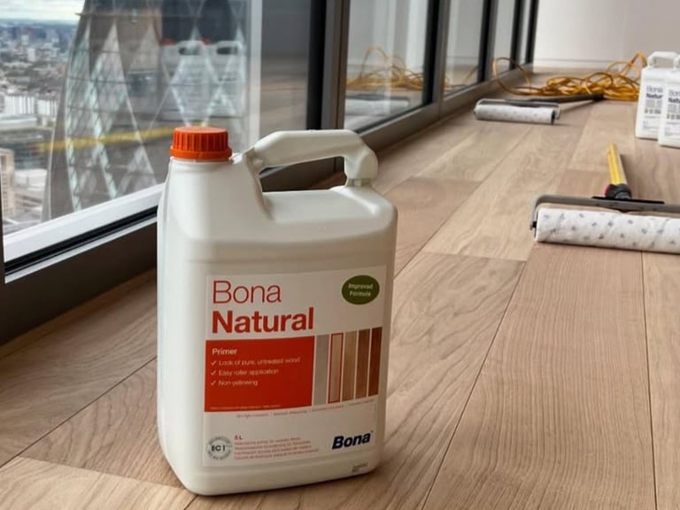 Bona Natural hardwood floor cleaner bottle on wooden floor in modern office with city view